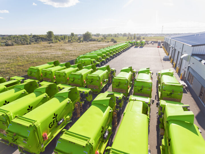 blurred image of GFL trash trucks parked in a lot