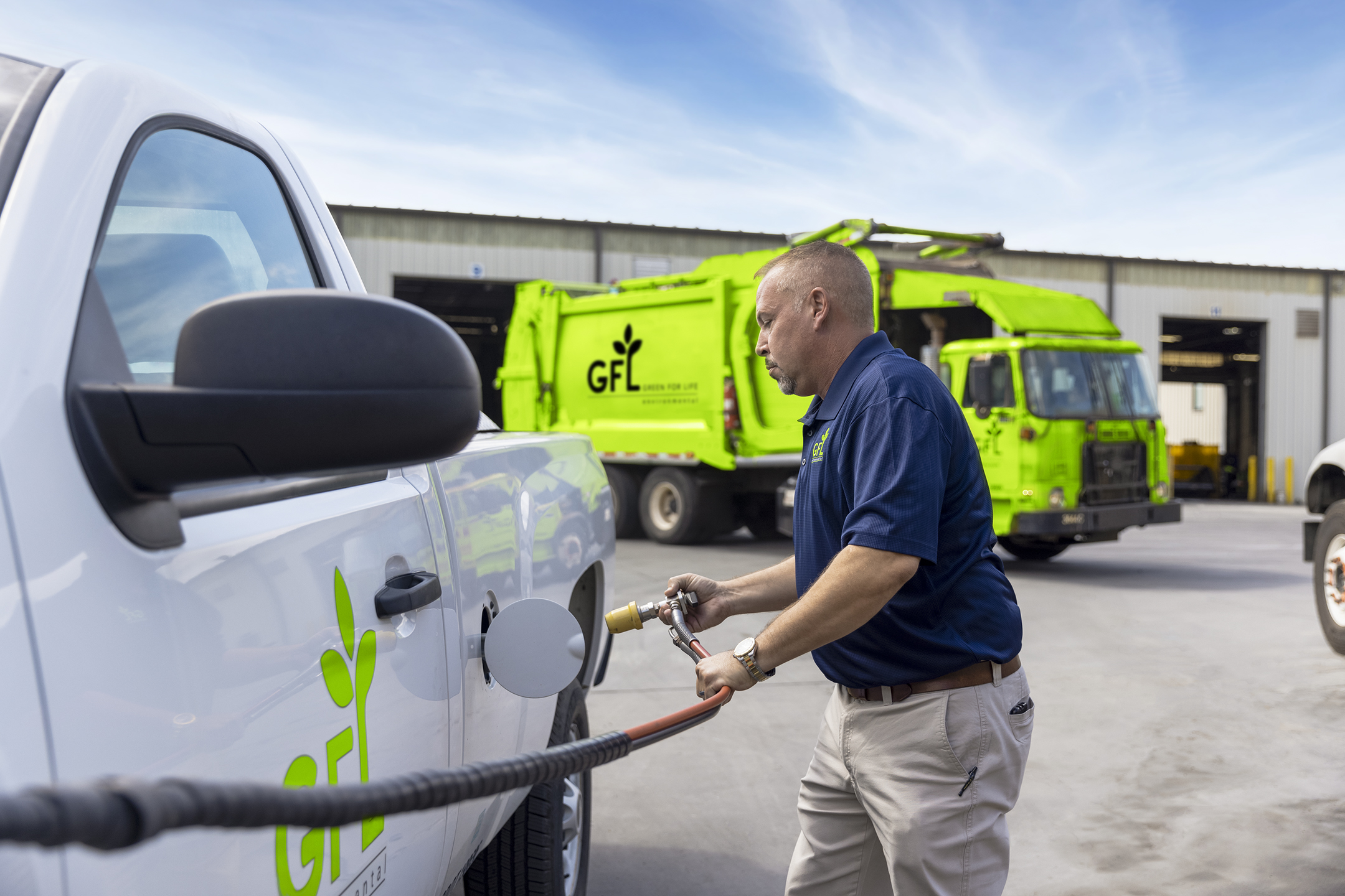 Employee filling up a CNG GFL truck